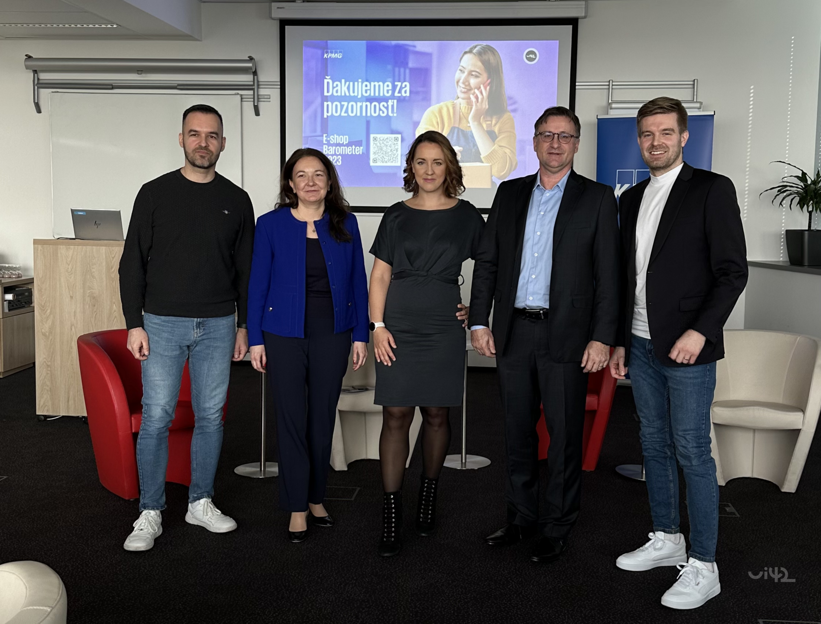 A group of people stands in front of a projection screen with the text 'Thank you for your attention!' in a conference room.