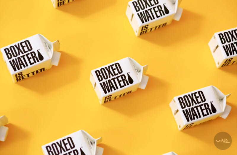 Boxes with the inscription Boxed Water Is Better on a yellow background