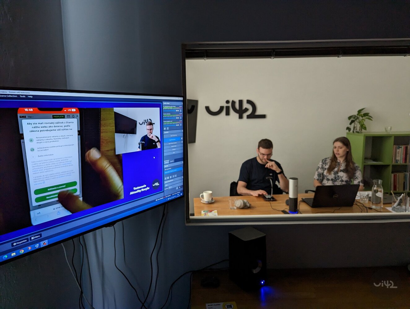 Usability testing in an office with two people at a table and a screen displaying a mobile application.