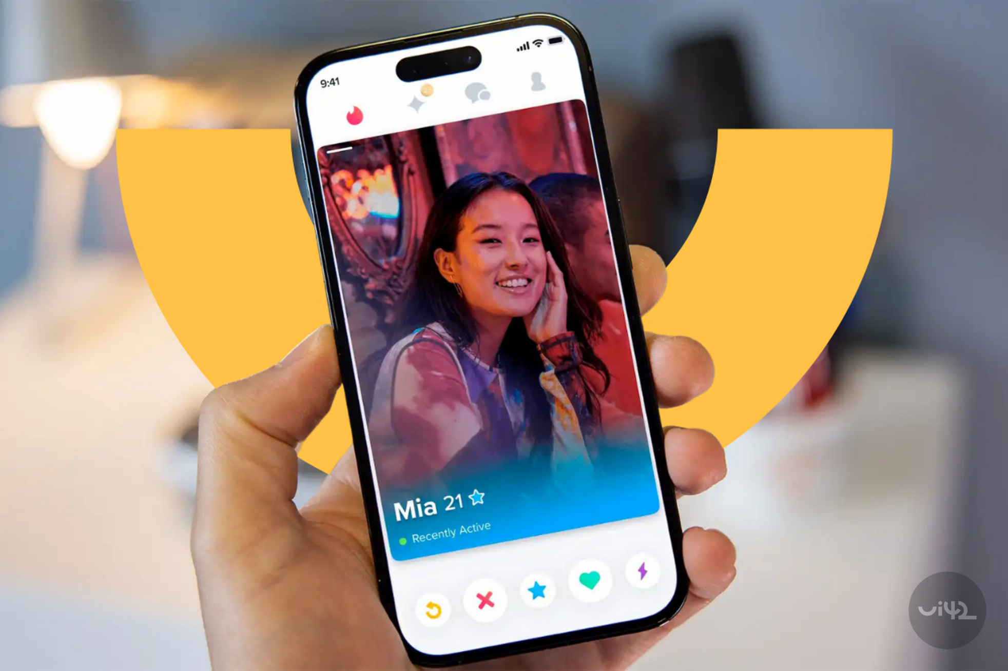 A person holding a mobile phone displaying the Tinder app and a user profile named Mia.
